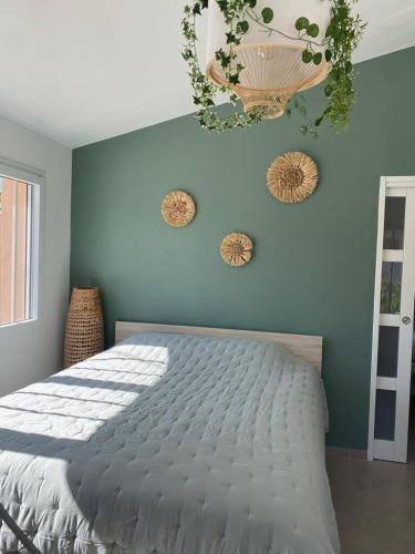 une chambre avec un lit et un mur bleu dans l'établissement La villa MARIE, à Cavaillon