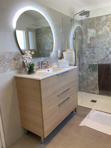 une salle de bain avec un lavabo et un miroir dans l'établissement La villa MARIE, à Cavaillon