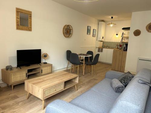 un salon avec un canapé, une télévision et une table dans l'établissement Les Carmélites : central à 5 min à pied de la Gare, à Poitiers