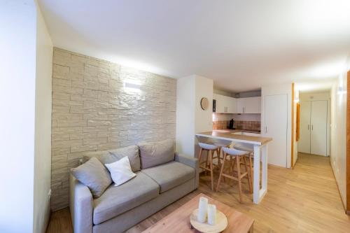 un salon avec un canapé et une cuisine dans l'établissement T2 au cœur du centre historique de Briançon #1, à Briançon
