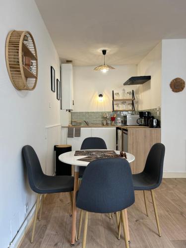 - une table à manger et des chaises dans la cuisine dans l'établissement Les Carmélites : central à 5 min à pied de la Gare, à Poitiers