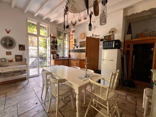 une cuisine avec une table, des chaises et un réfrigérateur dans l'établissement La Dépendance, à Tours