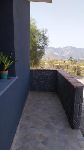 a patio with a bench and a view of the desert at Il Calice dell'Etna in Passopisciaro
