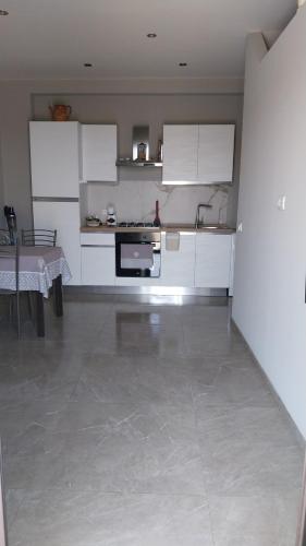 a kitchen with white cabinets and a tile floor at Il Calice dell'Etna in Passopisciaro