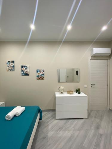 una camera con letto, lavandino e luci di Le Case del Cavaliere ad Acireale