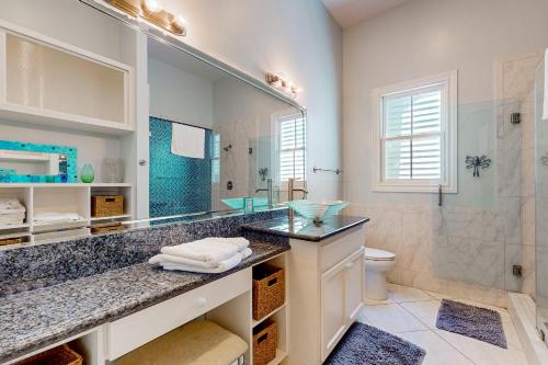 a bathroom with a sink and a large mirror at Under the Avenue in Galveston