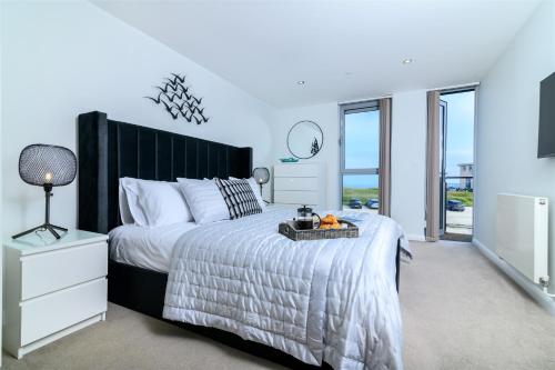 a bedroom with a large bed with a black headboard at The Penthouse, 48 Zinc in Newquay
