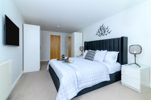 a bedroom with a large bed with a black headboard at The Penthouse, 48 Zinc in Newquay