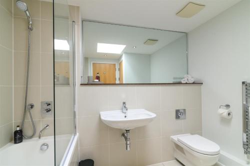 a bathroom with a sink and a toilet and a mirror at The Penthouse, 48 Zinc in Newquay