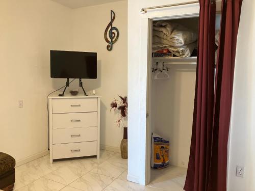 a bedroom with a tv and a dresser with a dresser with a television at Eitalys on Paris in Hannibal