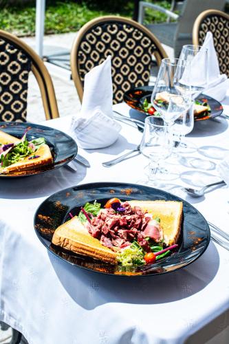 a table with two plates of food on it at Logis Hôtel - Le Relais du Parisis in Villeparisis