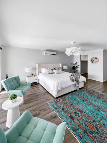 a bedroom with a bed and a couch and a rug at Your Perfect Coastal Getaway in Corinella