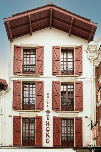 a building with brown shutters on a building at Boutique Hôtel Txoko in Saint-Jean-de-Luz