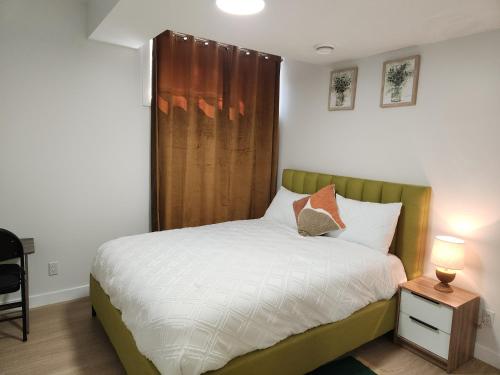 a bedroom with a bed with a wooden headboard at Brand New Deluxe 2 Bedroom Suite with AC & Den in Calgary
