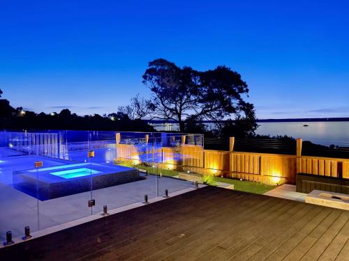 a house with a swimming pool at night at Your Perfect Coastal Getaway in Corinella
