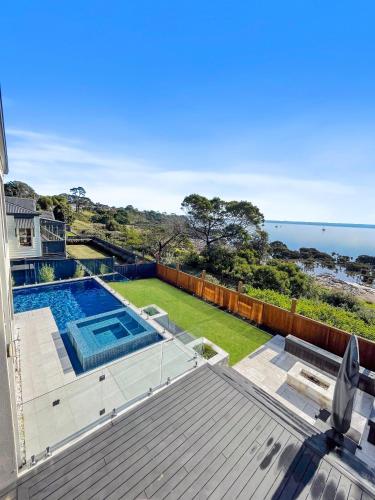 an ocean view from the balcony of a house with a swimming pool at Your Perfect Coastal Getaway in Corinella