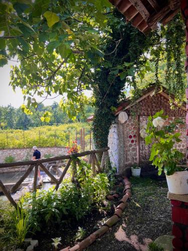 a man standing next to a fence in a garden at Cottage ,,Okatsia” ოკაციას კოტეჯები in Gordi
