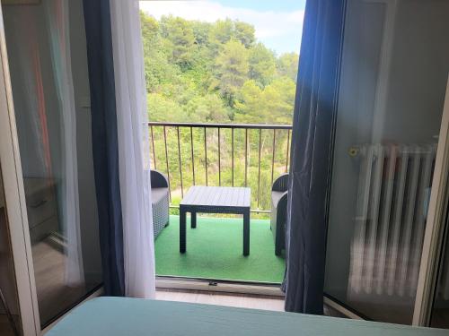 Cette chambre dispose d'un balcon avec une fenêtre et une table. dans l'établissement Private Room-2 in HANNANA Apartment- 2 min walk To Tram 12 min to Nice train station 15 min to Massena Place, à Nice