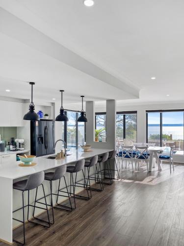 a kitchen with a large island with bar stools at Your Perfect Coastal Getaway in Corinella