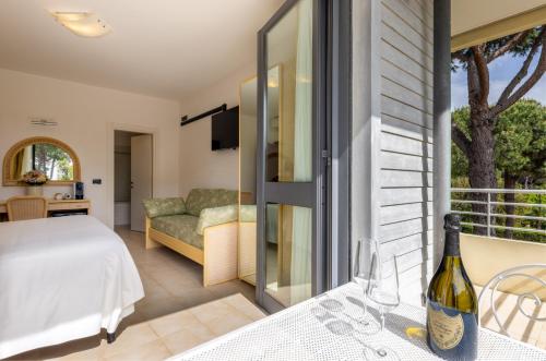 a room with a bed and a table with wine glasses at Hotel Acapulco in Forte dei Marmi