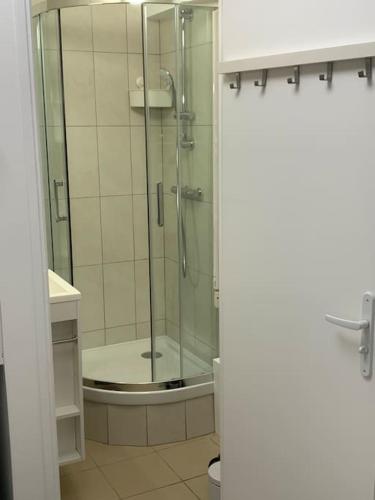 a bathroom with a shower with a glass door at Charmant Studio-Proche gares in Versailles