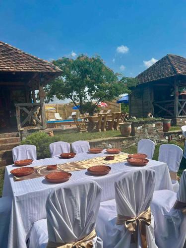 a table with white chairs and plates of food on it at Etno selo Smederevo PEPE- Serbia in Landol