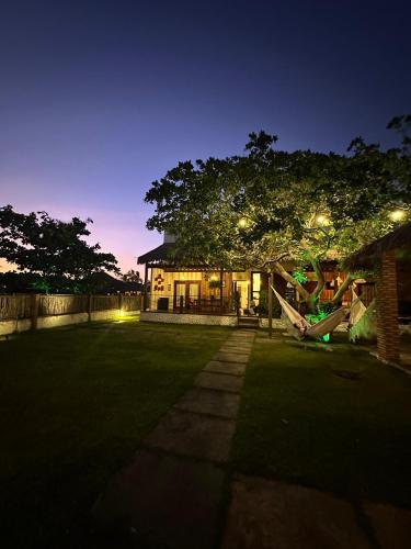 a house with a playground in the yard at night at Cel de Atins Chalé - Lençóis in Atins
