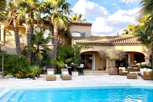 une maison avec une piscine et des palmiers dans l'établissement Charming villa with pool Hyères, à Hyères