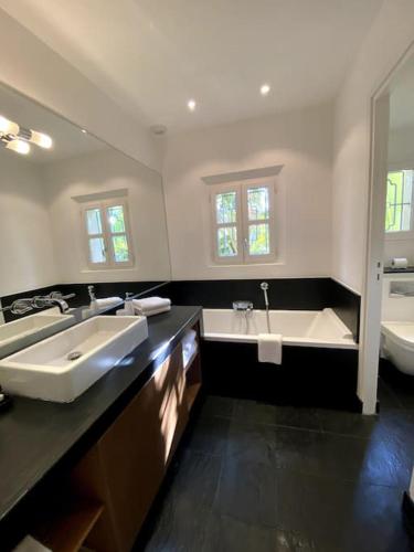 La grande salle de bains est pourvue de 2 lavabos et d'une baignoire. dans l'établissement Charming villa with pool Hyères, à Hyères