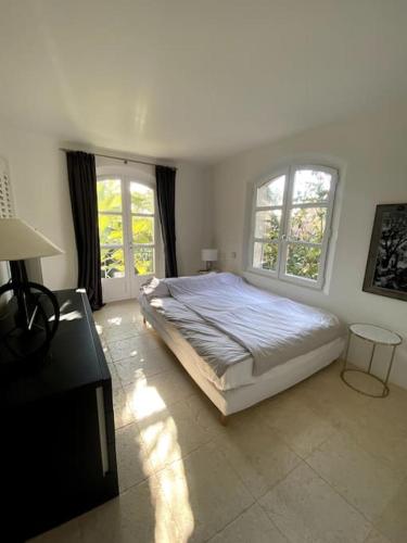 une chambre avec un grand lit et deux fenêtres dans l'établissement Charming villa with pool Hyères, à Hyères