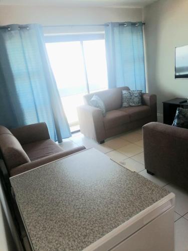 a living room with two couches and a couch at 88 on Stella Maris in Amanzimtoti