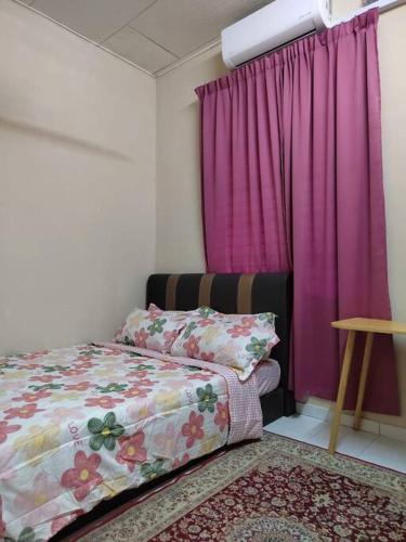 a bedroom with a bed and a pink curtain at Amin Homestay Taman Kenari Kulim in Kulim