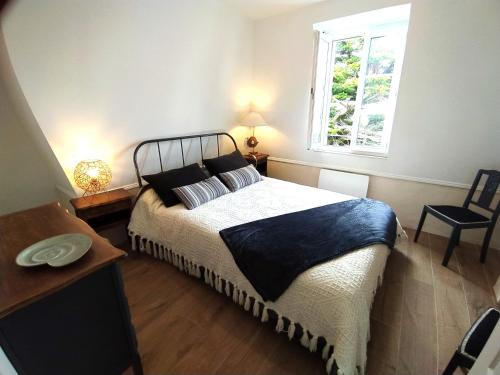 une chambre avec un grand lit et une fenêtre dans l'établissement VILLA la Vigie Location de vacances bord de mer plage Utah Beach Normandie, à Quinéville