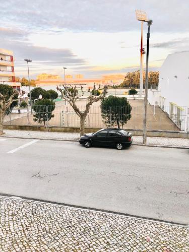 a black car parked on the side of a street at Cantinho do Liceu in Figueira da Foz