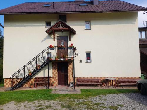 a white house with a staircase on the side of it at Noclegi u Daszyka in Polańczyk