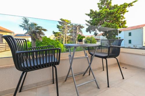 two chairs and a table on a balcony at Aparthotel OLIVE with jacuzzi and breakfast in Novalja