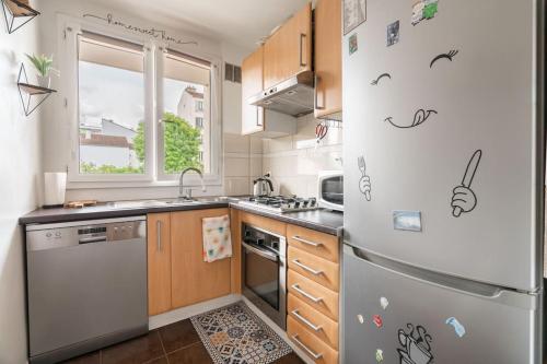 - une cuisine équipée d'un réfrigérateur avec des autocollants dans l'établissement Un Ravissant 1 CH et 1SDB à Alforville, à Alfortville