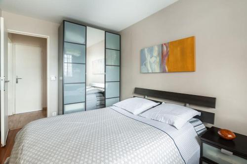 une chambre avec un lit blanc et un miroir dans l'établissement Un Ravissant 1 CH et 1SDB à Alforville, à Alfortville