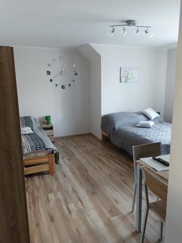 a bedroom with a bed and a clock on the wall at Chruścielówka ap nr 1 in Tylicz