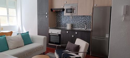 a living room with a couch and a kitchen at Apartamento en Avilés Céntrico & Parking in Avilés