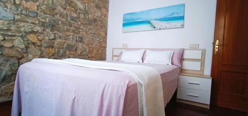 a bedroom with a bed and a stone wall at Apartamento en Avilés Céntrico & Parking in Avilés