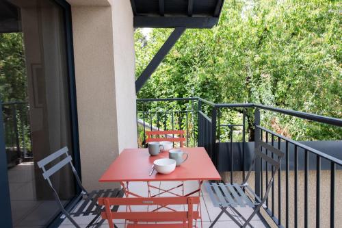 a red table and chairs on a balcony at Suite Kella 2 - Tassin - Beau studio rénové in Tassin-la-Demi-Lune