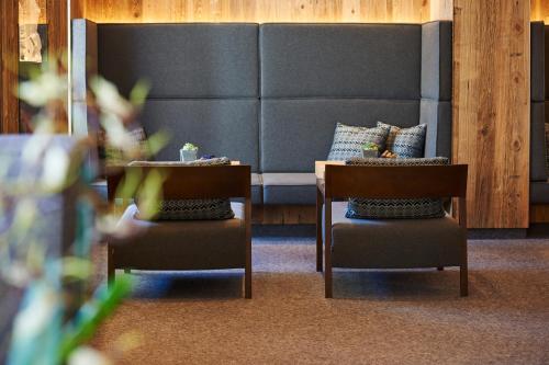 a living room with two chairs and a couch at Alpenhotel Laurin in Hochgurgl