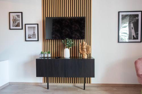 a living room with a black and gold striped wall at Suite Kella 2 - Tassin - Beau studio rénové in Tassin-la-Demi-Lune