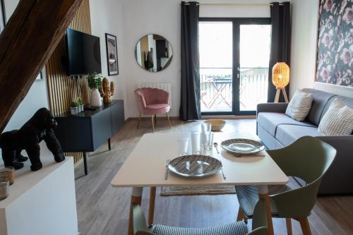 a living room with a table and a couch at Suite Kella 2 - Tassin - Beau studio rénové in Tassin-la-Demi-Lune