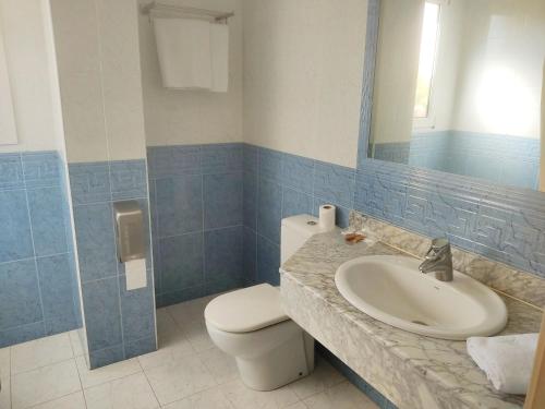 a bathroom with a sink and a toilet and a mirror at Hotel Suite Mioño Castro Urdiales in Castro-Urdiales
