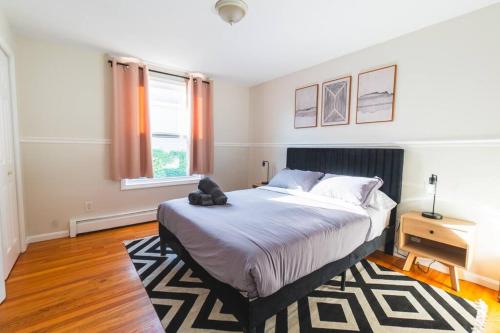 a bedroom with a large bed and a desk and a window at Roomy Boston 5BD-3BA-Pool Table-Free Parking in Revere