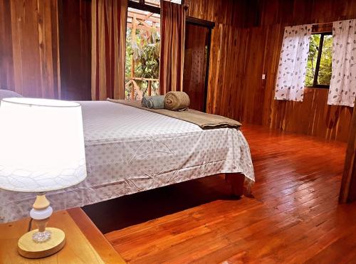 a bedroom with a bed and a wooden floor at Río Celeste, Cacahua Lodge in Rio Celeste