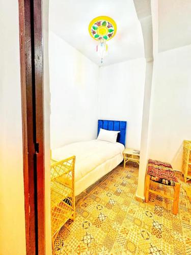 a bedroom with a bed and a chair in a room at Hostel Tanger Medina in Tangier