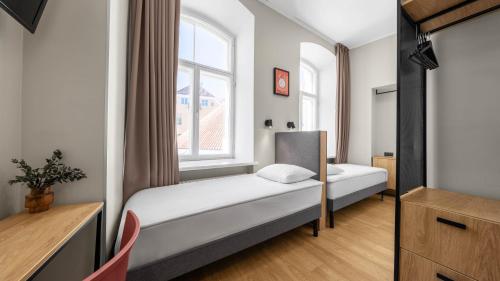 a small bedroom with a bed and a window at Rija Old Town Hotel in Tallinn